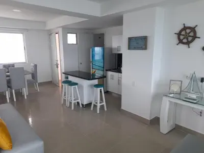 a kitchen with a counter and stools in a room at 2 Bedroom Beachfront Apartment 2P1-Al4 With Pool And WIFI in Cartagena de Indias
