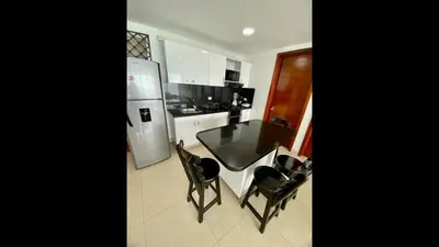 a kitchen with a table and two chairs and a refrigerator at 2 Bedroom Beachfront Apartment 2P1-Al2 With Pool And WIFI in Cartagena de Indias