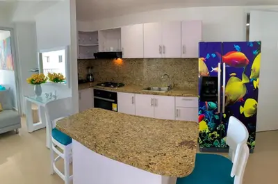 a kitchen with white cabinets and a counter top at 2 Bedroom Beachfront Apartment in Cartagena de Indias