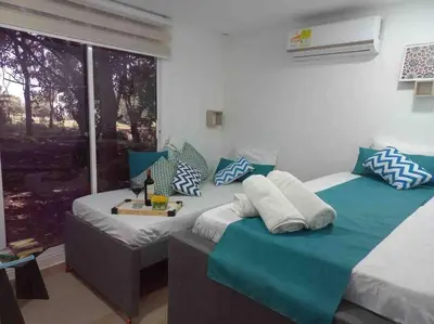 two beds in a room with blue and white pillows at Linda cabaña en Isla Tierra Bomba frente a Cartagena in Cartagena de Indias