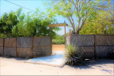 a wooden fence with a plant in front of it at Linda cabaña en Isla Tierra Bomba frente a Cartagena in Cartagena de Indias