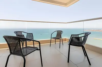 three chairs and a table in front of a window at Laurdhomes Palmetto Beach Floor 32, Sea View, 3HBT in Cartagena de Indias