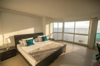 a bedroom with a bed with a view of the ocean at 2B/2B Gorgeous Sunsets-Ocean View -Pool in Cartagena de Indias