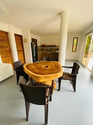 a dining room with a wooden table and chairs at Cabaña cerca al Mar con Pisicina y AC en Tolú in Tolú