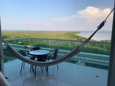 a hammock on a balcony with a table and chairs at Apartamento Morros 922 in Cartagena de Indias