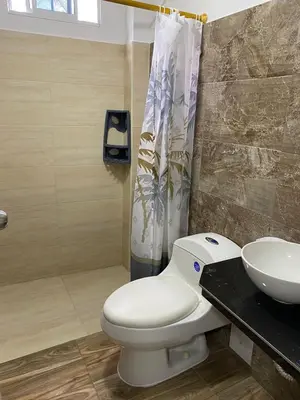 a bathroom with a white toilet and a sink at Casa Hotel Isabella in Santa Marta