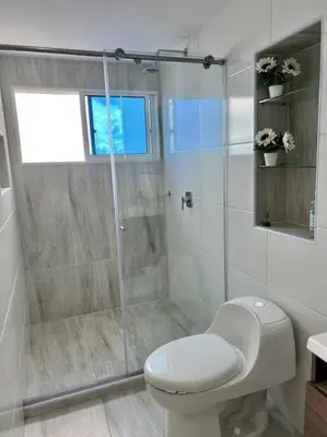 a bathroom with a toilet and a glass shower at Relax y Confort - Apartamento frente al Mar in Cartagena de Indias