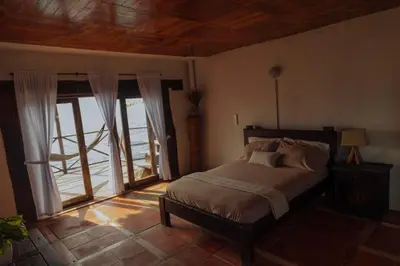 a bedroom with a bed and a large window at Isla Kalua - Private Ocean Villa in Isla Pavitos