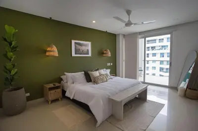 a bedroom with a bed and a green wall at Condominio frente al mar con acceso directo a la playa Morros Epic. in Cartagena de Indias
