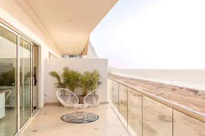 a balcony with two chairs and a view of the beach at Condominio frente al mar con acceso directo a la playa Morros Epic. in Cartagena de Indias
