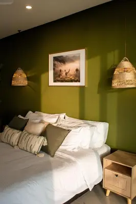 a bedroom with a white bed with a green wall at Condominio frente al mar con acceso directo a la playa Morros Epic. in Cartagena de Indias