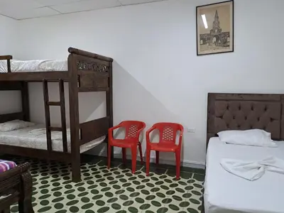 two red chairs and a bed in a room with bunk beds at Hostal Casa Lara in Cartagena de Indias