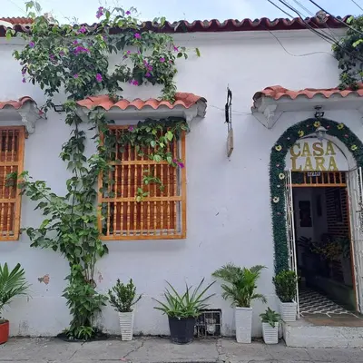 a white building with plants and a sign on it at Hostal Casa Lara in Cartagena de Indias