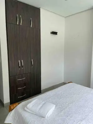 a bedroom with a bed and a wooden cabinet at Apartamento en Coveñas cerca al mar #204 in Coveñas