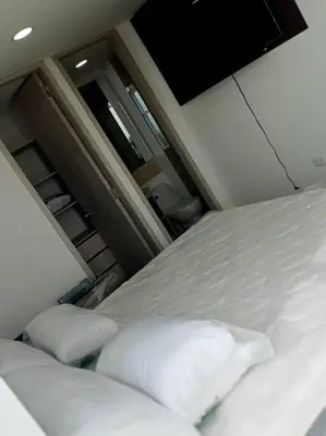a white bed with two pillows in a room at Apto Vista Mar 2 cuadras Playa, Jaccuzi BBQ Wifi Parqueadero y Ascensor 7 Piso in Santa Marta