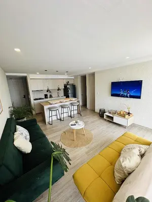a living room with a green couch and a table at Dominiqueplayaazul apto de lujo con Jacuzzi privado en balcon in Cartagena de Indias