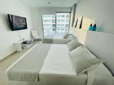 a bedroom with two beds and a flat screen tv at Cartagena- Apto con acceso y vista al mar Morros Ultra in Cartagena de Indias