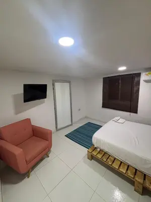 a bedroom with a bed and a chair and a television at Wonderful trinity beach house in crespo. in Cartagena de Indias