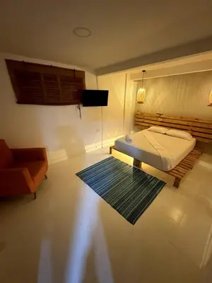a bedroom with a bed and a chair and a rug at Wonderful trinity beach house in crespo. in Cartagena de Indias
