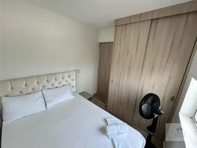 a bedroom with a white bed and a fan at Brisa de la Bahia in Cartagena de Indias