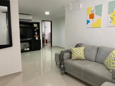 a living room with a couch and a television at Habitación en apartamento compartido al frente del cc Unico in Barranquilla