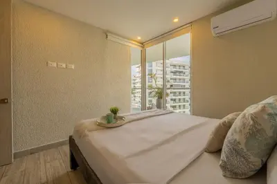 a bedroom with a large bed and a window at DQ1102 Hermoso con Jacuzzi priv y Vista increíble - 10 min Centro Historico in Cartagena de Indias