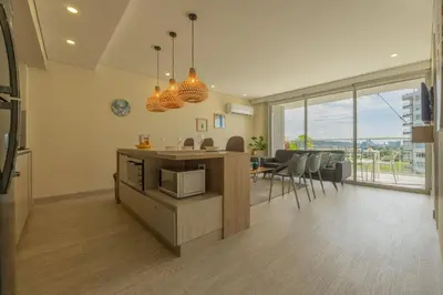 a kitchen and living room with a counter with a microwave at MQ1003 | Jacuzzi privado · Relax en Cielo Mar in Cartagena de Indias