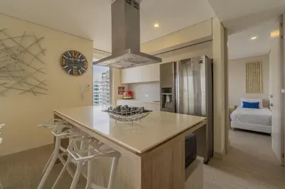 a kitchen with a counter and a clock on the wall at MQ1206 | Lujo, vista y jacuzzi privado 2BD in Cartagena de Indias