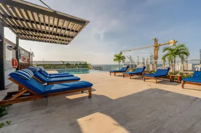 a patio with blue lounge chairs and a pool at MQ1206 | Lujo, vista y jacuzzi privado 2BD in Cartagena de Indias