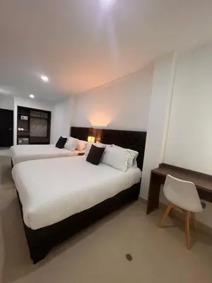 a hotel room with two beds and a desk at Hotel Zuriel Boutique in Cartagena de Indias