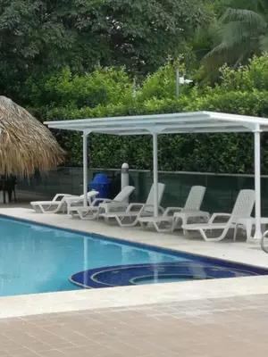 a group of chairs and umbrellas next to a swimming pool at Costa Azul Suites 63 in Playa Dormida