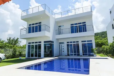 a house with a swimming pool in front of it at Beach cabin near Barranquilla in Santa Veronica