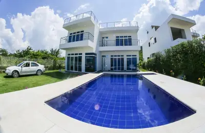a villa with a swimming pool in front of a house at Beach cabin near Barranquilla in Santa Veronica