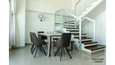 a dining room with a table and chairs and a staircase at Espectacular Duplex con vista al mar in Cartagena de Indias
