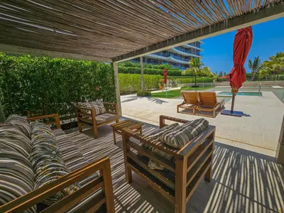 a patio with couches and chairs on a deck at Apartamento en Condominio con acceso directo al mar en Cartagena in Cartagena de Indias