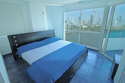 a bedroom with a bed with a view of the city at Apartamento de 3 habitaciones, 1103 in Cartagena de Indias