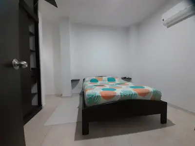 a small bed in a room with a white wall at Apartaestudio Cartagena 4P in Cartagena de Indias
