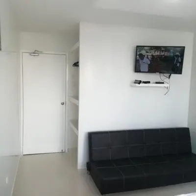 a living room with a black couch and a tv at Estudio tipo Loft Amoblado en Bocagrande Cartagena 801A in Cartagena de Indias