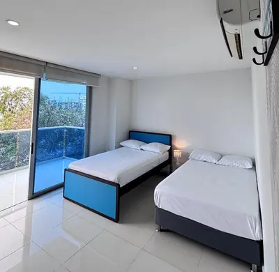 a bedroom with two beds and a large window at Hermoso Apto Familiar en sector Bello Horizonte in Santa Marta