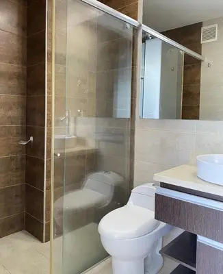 a bathroom with a toilet and a glass shower at Hermoso Apto Familiar en sector Bello Horizonte in Santa Marta