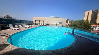 a man is standing in a large swimming pool at Hermoso Apto Familiar en sector Bello Horizonte in Santa Marta