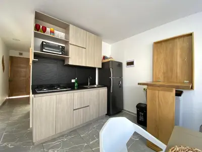 a kitchen with wooden cabinets and a stainless steel refrigerator at Apartamento en condominio con vista al mar in San Bernardo del Viento