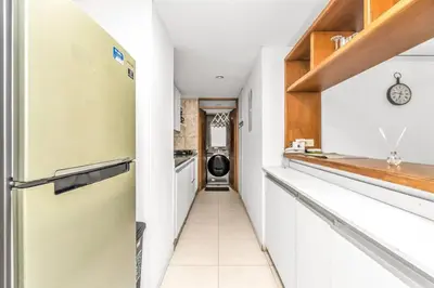 a kitchen with white cabinets and a refrigerator at Beachside Escape 2BR with Pool in Cartagena de Indias