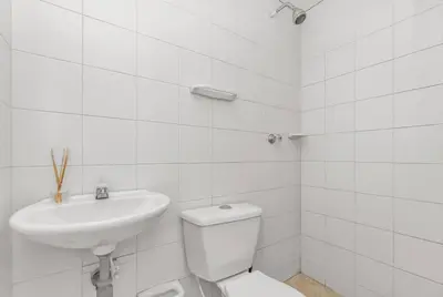 a white bathroom with a toilet and a sink at Beachside Escape 2BR with Pool in Cartagena de Indias