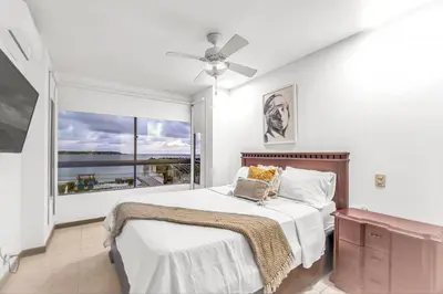 a bedroom with a bed and a large window at Beachside Escape 2BR with Pool in Cartagena de Indias