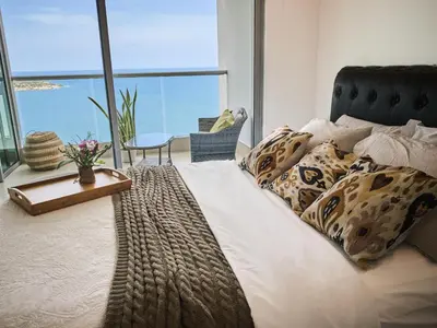 a bedroom with a bed with a view of the ocean at Sea, Sand & Skyline 30th-Floor Poolside Getaway in Cartagena de Indias