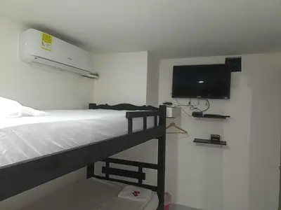 a bedroom with a bunk bed and a flat screen tv at HOSTAL EL ALTISIMO in Cartagena de Indias