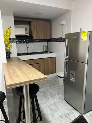 a kitchen with a wooden table and a refrigerator at Apartamento -Laguito-Bocagrande in Cartagena de Indias