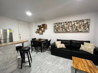 a living room with a black couch and a table at Apartamento -Laguito-Bocagrande in Cartagena de Indias