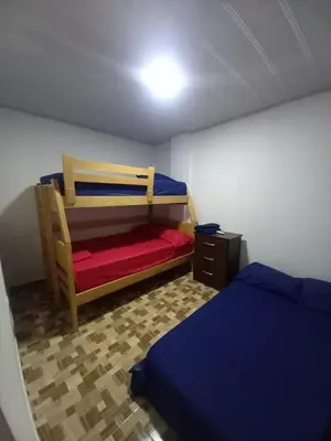 a small bedroom with two beds and a night stand at Apartahotel Los Ángeles in Cartagena de Indias